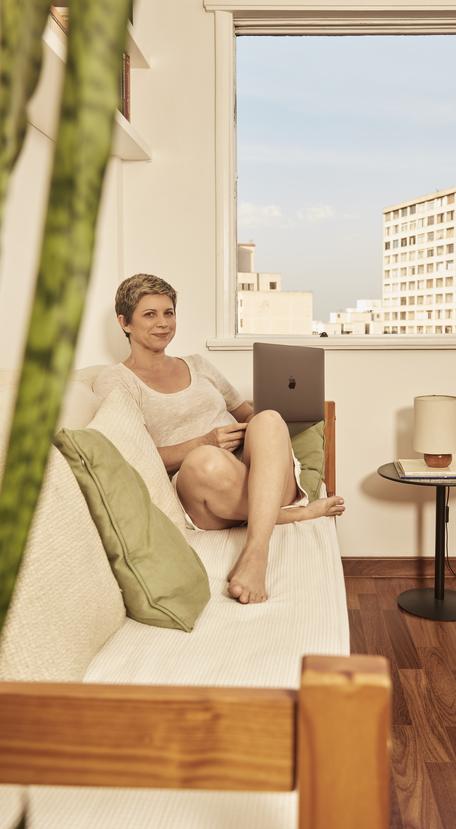 mulher sentada em um sofá com um notebook